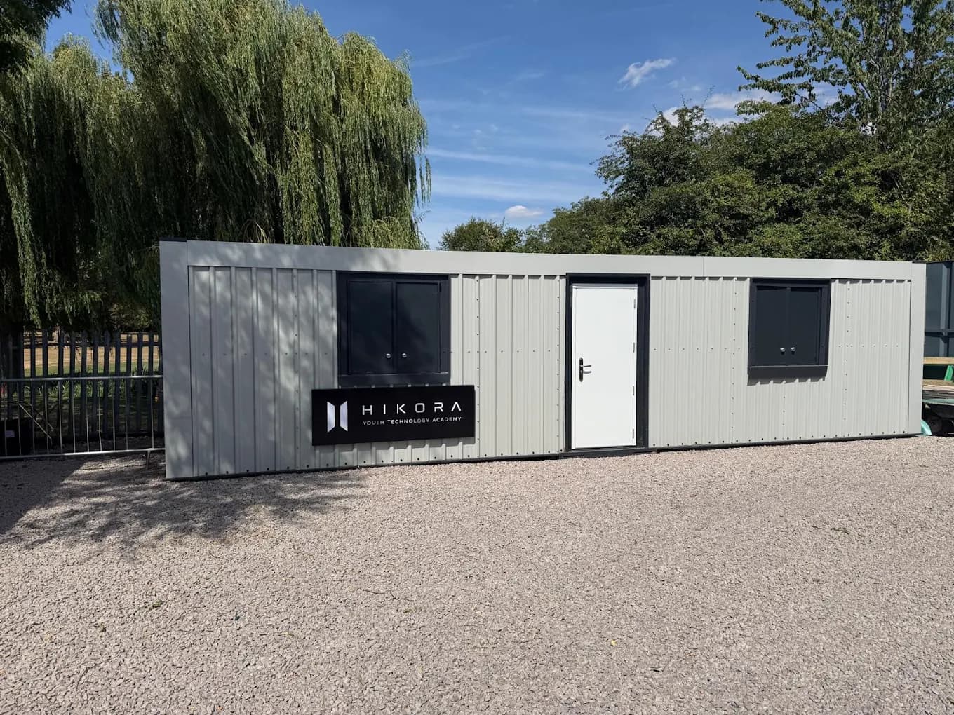 The Hikora centre at Mowmacre Sports Ground in Leicester - a single-storey grey building with a black Hikora sign beside the entrance door.